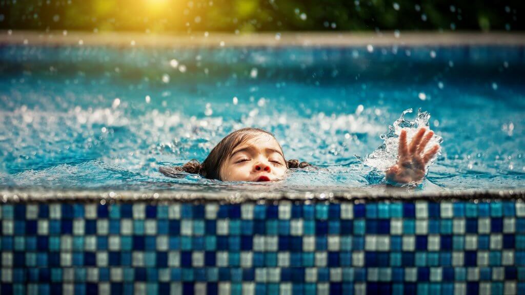 Baby girl drowning in pool. Danger and children Concept. Pools a