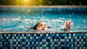 Baby girl drowning in pool. Danger and children Concept. Pools a